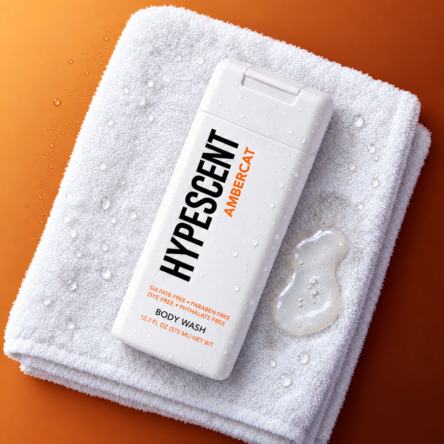 HYPESCENT Ambercat body wash bottle on a white towel next to a drop of clear gel
