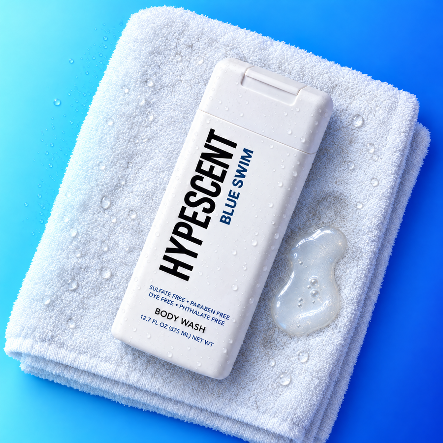 HYPESCENT Blue Swim body wash bottle on a white towel next to a drop of clear gel