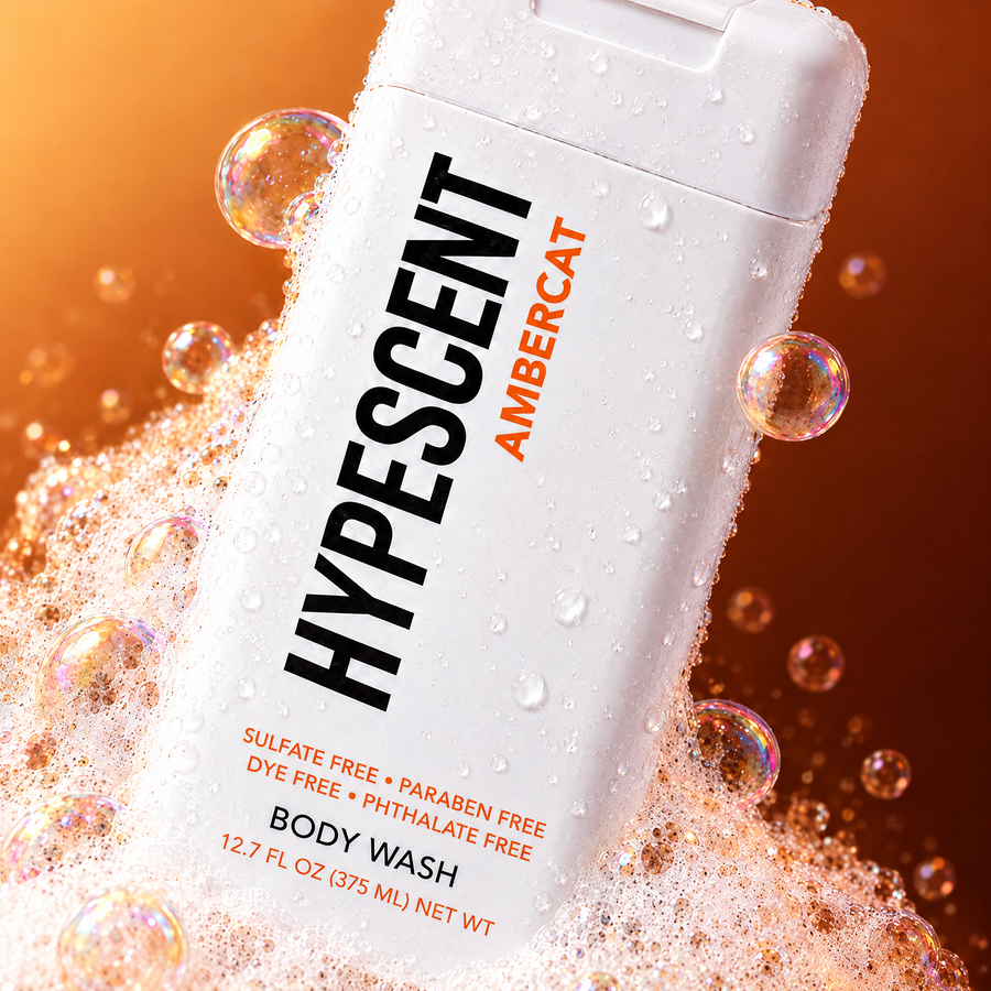 Close-up of the HYPESCENT Ambercat body wash label with rich foam and bubbles