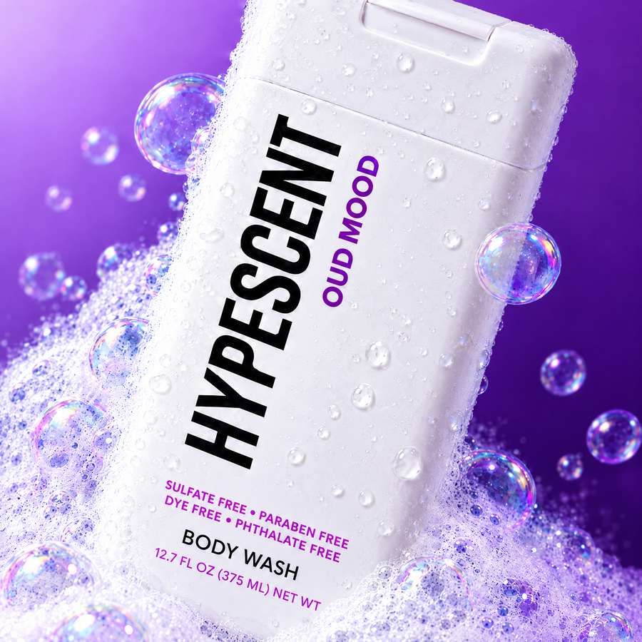 Close-up of the HYPESCENT Oud Mood body wash label with rich foam and bubbles