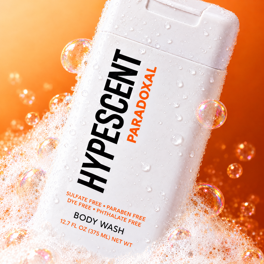 Close-up of the HYPESCENT Paradoxal body wash label with rich foam and bubbles