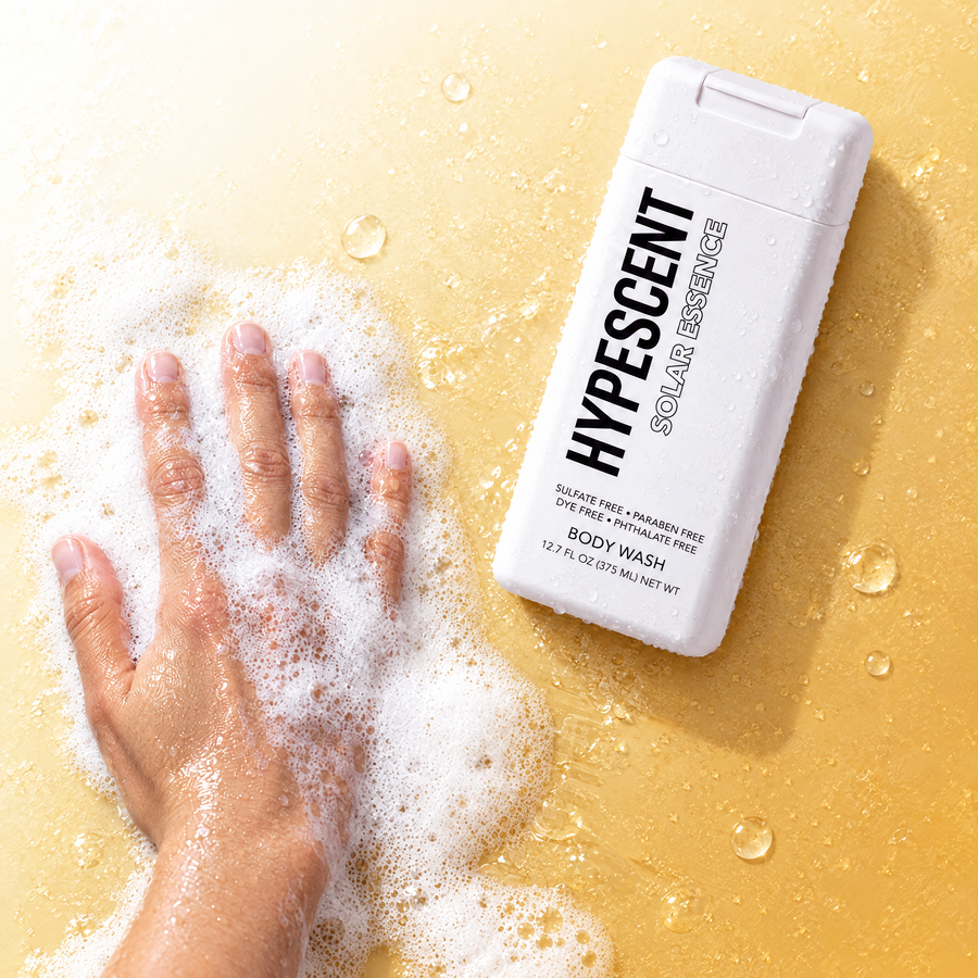 Hand lathering HYPESCENT Solar Essence body wash into a rich foam